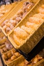 Fresh golden breads with melted cheese wrapped in plastic wrap in wicker basket in bread department of supermarket Royalty Free Stock Photo