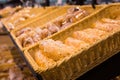 fresh golden breads with melted cheese wrapped in plastic wrap in wicker basket in bread department of supermarket Royalty Free Stock Photo