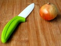 fresh golden brown and green onion. natural bamboo cutting board. white and green ceramic knife