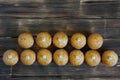 Fresh golden cupcakes with letters lie on a wooden rustic table made of pine boards. Bon appetite