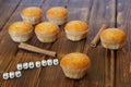 Fresh golden muffins with cinnamon sticks lie on a wooden surface made of pine boards. Bon appetite. Tasty and healthy food