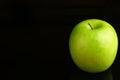 A fresh Granny Smith apple on a black background. Royalty Free Stock Photo