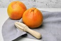 Fresh grapefruit citrus fruits with wooden hand squeezer on white table background with linen napkin Royalty Free Stock Photo