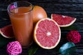 Fresh grapefruit juice in a clear glass grapefruit slices green leaves