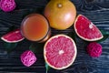 Fresh grapefruit juice in a clear tall glass grapefruit slices on a dark wooden background