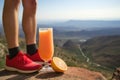 fresh grapefruit juice in a tall glass in front of man hiking