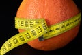 Fresh grapefruit wrapped with measuring tape. The concept of healthy nutrition, weight loss, dietetics Royalty Free Stock Photo