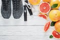 Fresh grapefruits and grapefruit juice and rope on rustic white wooden table, fitness accessories. Concept of slimming Royalty Free Stock Photo