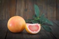 Fresh grapefruits with leaves on wooden background