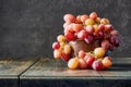 Fresh grapes. Bunches of different varieties in a plate on an old wooden table and dark background. Royalty Free Stock Photo