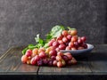 Fresh grapes. Bunches of different varieties in a plate on an old wooden table and dark background. Royalty Free Stock Photo