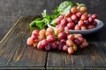 Fresh grapes. Bunches of different varieties in a plate on an old wooden table and dark background. Royalty Free Stock Photo