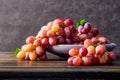 Fresh grapes. Bunches of different varieties in a plate on an old wooden table and dark background. Royalty Free Stock Photo