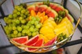 Fresh Grapes, pineapple, watermelon, kiwi, grapefruit, oranges on fruit plate at festive event. Royalty Free Stock Photo