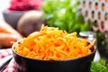 Fresh grated carrot in bowl closeup