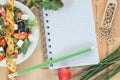 Fresh greek salad with feta cheese and tape measure with notepad for notes. Slimming and healthy nutrition Royalty Free Stock Photo