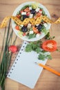 Fresh greek salad with feta cheese and tape measure with notepad for notes. Slimming and healthy nutrition Royalty Free Stock Photo