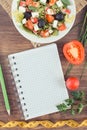 Fresh greek salad with feta cheese and tape measure with notepad for notes. Slimming and healthy nutrition Royalty Free Stock Photo