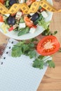 Fresh greek salad with feta cheese and tape measure with notepad for notes. Slimming and healthy nutrition Royalty Free Stock Photo