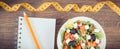 Fresh greek salad with feta cheese and tape measure with notepad for notes. Slimming and healthy nutrition Royalty Free Stock Photo