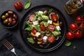 Fresh greek salad with tomato, cucumber, bel pepper , olives and feta cheese on black plate Royalty Free Stock Photo