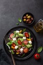 Fresh greek salad with tomato, cucumber, bel pepper , olives and feta cheese on black plate Royalty Free Stock Photo