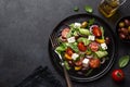 Fresh greek salad with tomato, cucumber, bel pepper , olives and feta cheese on black plate Royalty Free Stock Photo