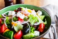 Fresh greek salad with tomato, cucumber, bel pepper, onion and feta cheese on green plate, top view Royalty Free Stock Photo