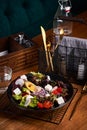 Fresh greek salad with tomato, radish, onion, bel pepper , olives and feta cheese on black plate, side view, wooden background Royalty Free Stock Photo