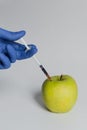 Apple injected with pesticides needle syringe