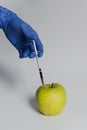 Apple injected with pesticides needle syringe