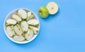 Fresh green apple slices on white plate on blue background Royalty Free Stock Photo