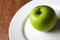 Fresh green apple on a white plate Royalty Free Stock Photo