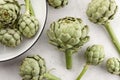 Fresh green artichokes on white stone background Royalty Free Stock Photo