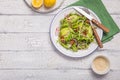 Fresh green arugula leaves on white bowl, rucola rocket salad with apple, radish, pecan nuts, onion on wooden rustic background Royalty Free Stock Photo