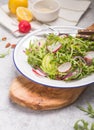 Fresh green arugula leaves on white bowl, rucola rocket salad with apple, radish, pecan nuts, onion on wooden rustic background Royalty Free Stock Photo