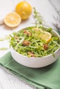 Fresh green arugula leaves on white bowl, rucola rocket salad on wooden rustic background with place for text. Selective focus, Royalty Free Stock Photo