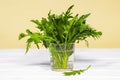 Fresh green arugula salad on glass with water on a wooden table. Simple rustic background, antioxidant and healthy food, Green Royalty Free Stock Photo