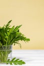 Fresh green arugula salad on glass with water on a wooden table. Simple rustic background, antioxidant and healthy food, Green Royalty Free Stock Photo