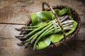 Fresh green asparagus in a basket on a rustic wooden table, view Royalty Free Stock Photo