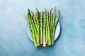 Fresh green asparagus in blue bowl top view. Healthy and diet organic food. Royalty Free Stock Photo