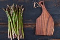 Fresh green asparagus bunches on black wooden background decorated with brown board Royalty Free Stock Photo