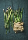 Fresh green asparagus in craft paper bag over grey cloth Royalty Free Stock Photo
