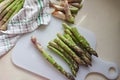 Fresh green asparagus on cutting board. Preparing asparagus for cooking: washing and peeling.