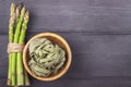 Fresh green asparagus and fettuccine italian pasta in bowl on wooden rustic background Royalty Free Stock Photo