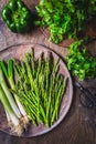 Fresh green asparagus with green onion and herbs on wooden table Royalty Free Stock Photo