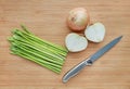 Fresh green asparagus and onion with sharp knife on wooden board background Royalty Free Stock Photo