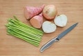 Fresh green asparagus, onion and sweet potato with sharp knife on wooden board background Royalty Free Stock Photo