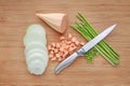 Fresh green asparagus, onion and sweet potato with sharp knife on wooden board background Royalty Free Stock Photo