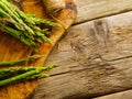 Fresh green asparagus shoots on a cutting board and a skein of twine on a wooden kitchen table. Close-up. Low angle view. Useful Royalty Free Stock Photo
